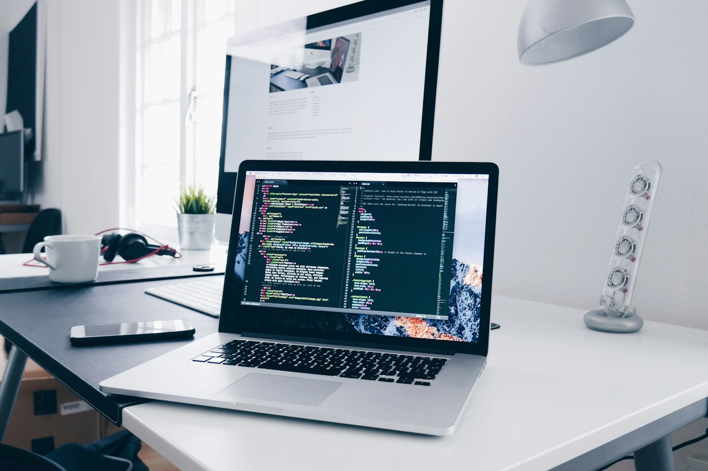 Code on a laptop at a desk